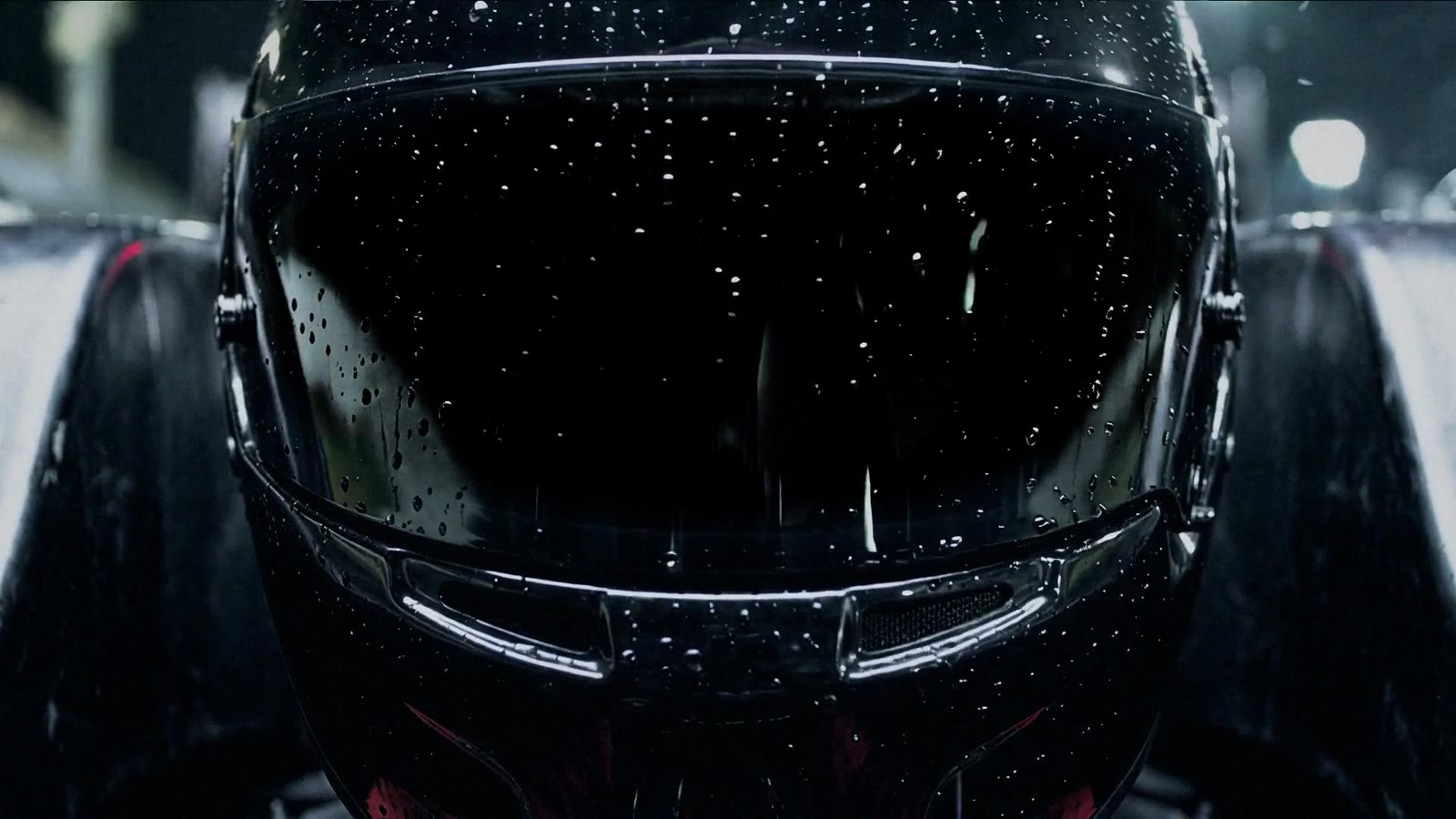 Rain on a black helmet visor at night